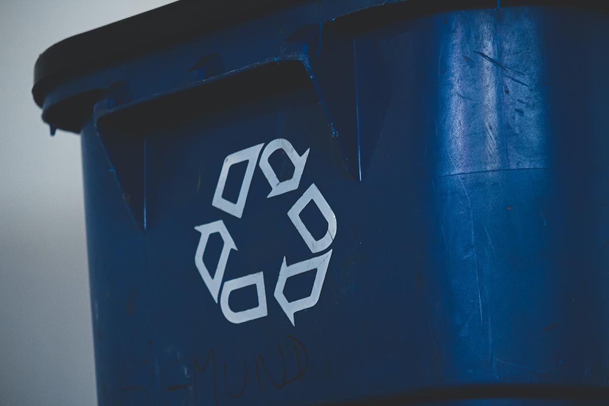 Niebieski pojemnik z symbolem recyklingu
