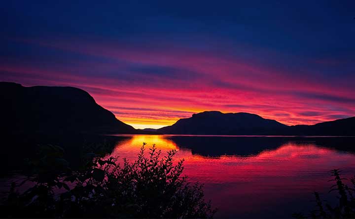Zdjęcie zachodu słońca nad jeziorem z pomarańczowym niebem
